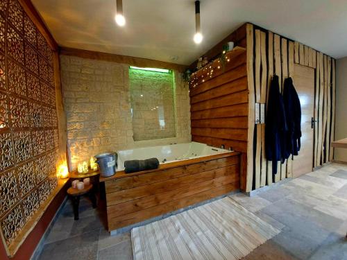 a large bathroom with a tub and wooden walls at La Casetta refuge méditerranéen et balnéo classé 3 étoiles in Wizernes