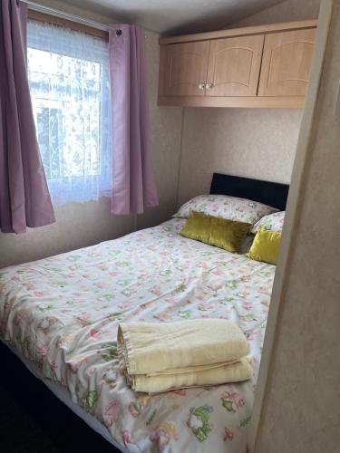 a bed in a room with pink curtains at Cocos haven in Ballantrae