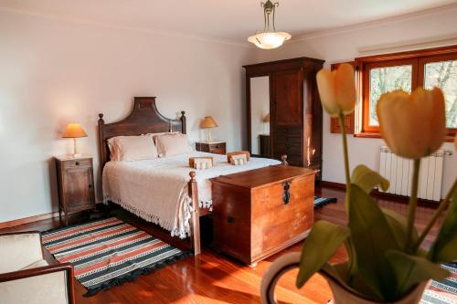 a bedroom with a bed with a dresser and a mirror at Casa Das Flores in Amares