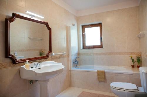 a bathroom with a sink and a toilet and a tub at Casa Das Flores in Amares
