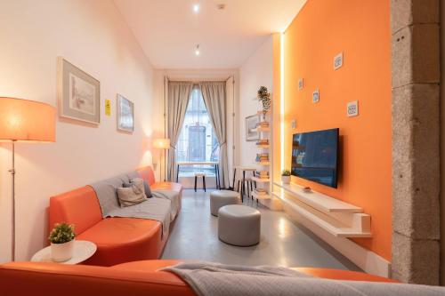 a living room with orange furniture and a flat screen tv at Porto Lounge Hostel & Guesthouse by Host Wise in Porto