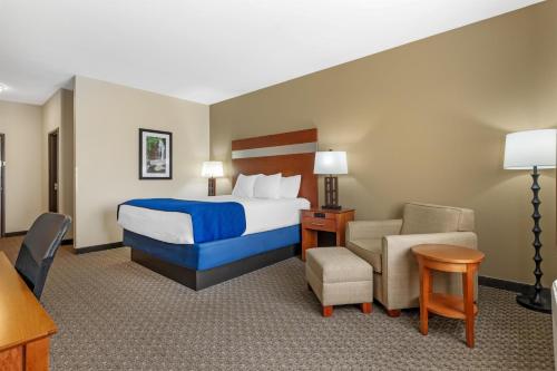 a hotel room with a bed and a chair at Best Western Big Spring Lodge in Neosho
