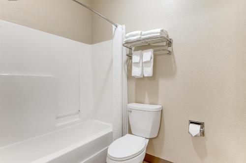 a white bathroom with a toilet and a bath tub at Best Western Big Spring Lodge in Neosho