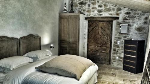 a bedroom with two beds and a stone wall at Le Domaine Saint Martin in Flassans-sur-Issole