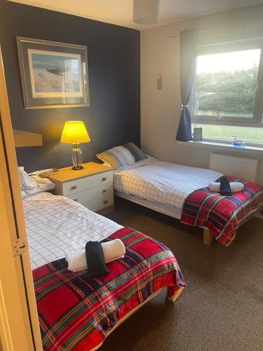 a bedroom with two beds and a window at 2-bed spacious apartment in Falkirk