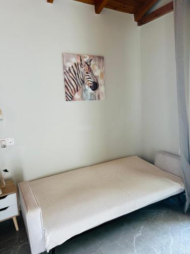 a bed in a room with a picture of a zebra at Mamour Apartments in Mavrovouni in Mavrovouni