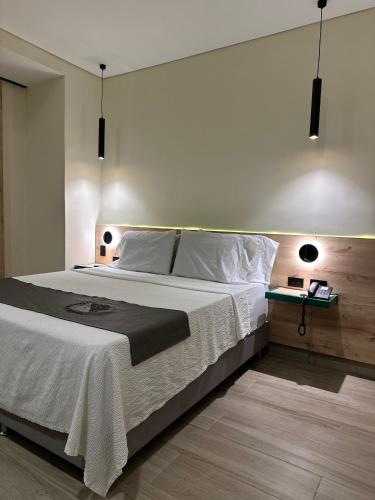 a bedroom with a large bed and a table at Mandala Medellín Belén By GyC Hotels in Medellín