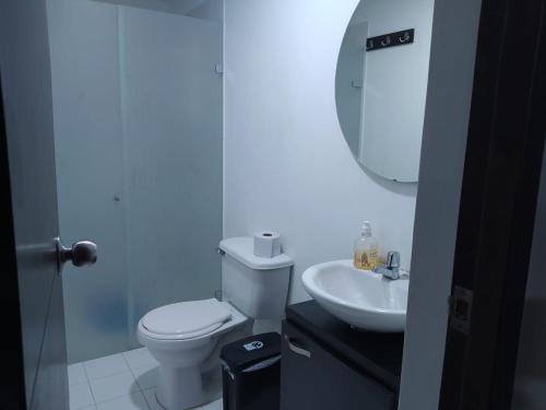 a bathroom with a white toilet and a sink at Apartasol Santafe de Antioquia in Santa Fe de Antioquia
