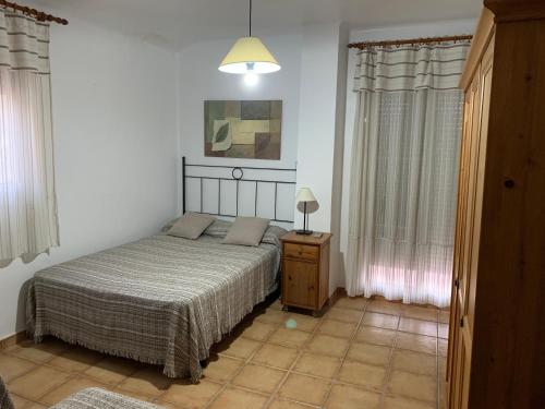 a bedroom with a bed and a lamp and curtains at Can Llorach in Sant Jaume d'Enveja