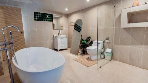 a bathroom with a tub and a toilet and a shower at Tulum Villa Resort Koh Samui in Bophut
