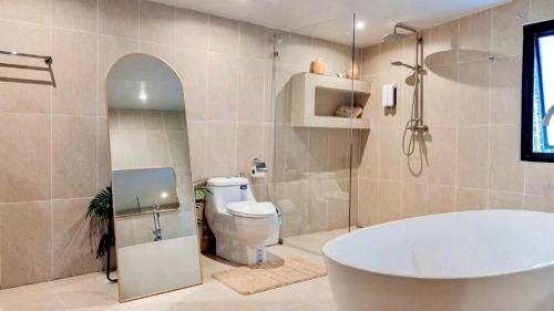 a bathroom with a tub and a toilet at Tulum Villa Resort Koh Samui in Bophut