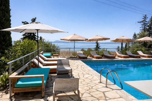 a pool with chairs and tables and umbrellas at Hotel Barbati - Seaside Getaways with Pool in Barbati
