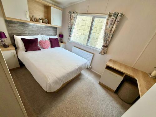 a small bedroom with a bed and a window at Rosies by the Sea in Walton-on-the-Naze