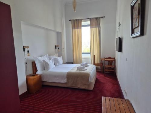 a hotel room with a bed and a window at Solar Do Conde Garden Hotel in Capelas