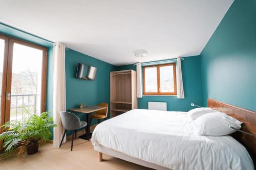a bedroom with blue walls and a bed and a desk at L'Azimut in Senez
