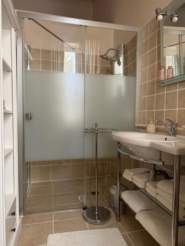 a bathroom with a glass shower and a sink at La Maison de Marie in Blaye