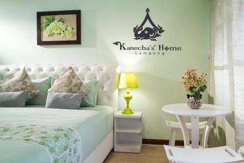 a bedroom with a white bed and a table at Kanecha's Home Lampang in Lampang