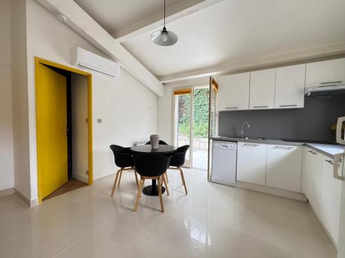 a kitchen with a table and chairs in a room at maison Eglantine in Gréoux-les-Bains