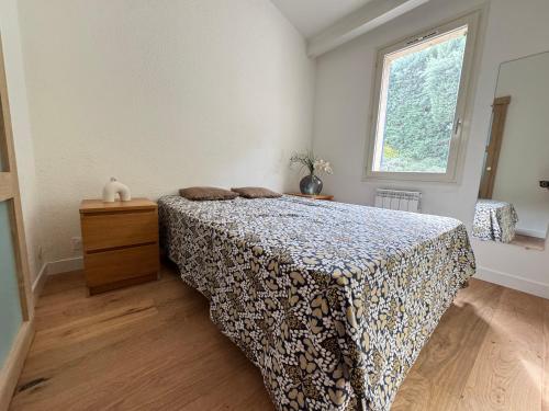 a bedroom with a bed and a window at maison Eglantine in Gréoux-les-Bains