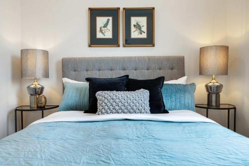 a bedroom with a blue bed with two lamps at 14BR Downtown Combo & Shared Seasonal Pool in New Orleans