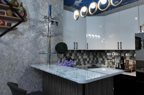 a kitchen with white cabinets and a white counter top at Green Corner Kutaisi in Kutaisi