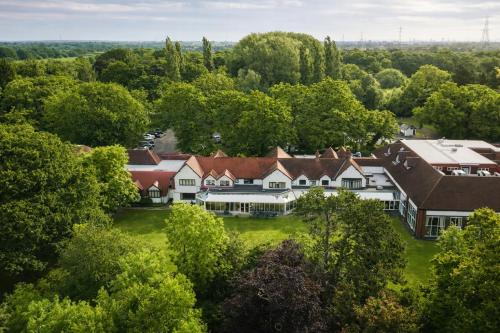 an aerial view of a mansion in the trees at Macdonald Craxton Wood Hotel & Spa, Chester in Ledsham