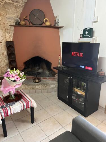 a living room with a tv and a fireplace at Friendly villagehouse in Paphos