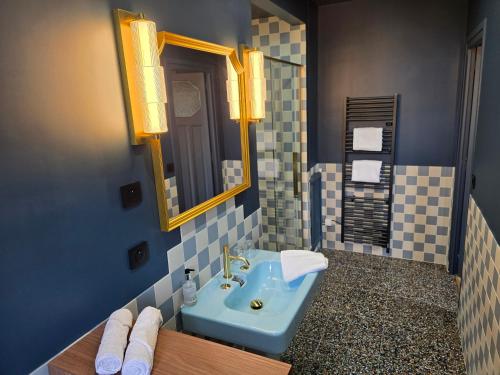 a bathroom with a blue sink and a mirror at Le Castel Guesthouse in Bayeux