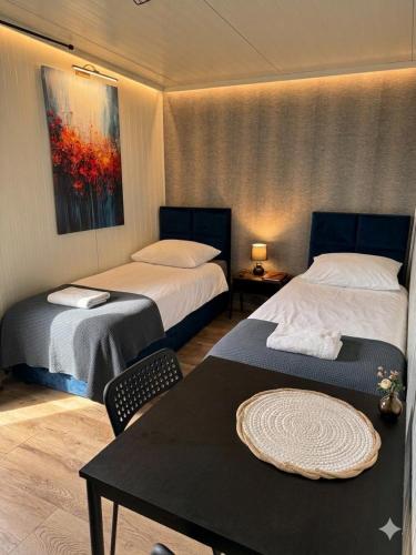 a hotel room with two beds and a table with at Domki303 in Mszczonów
