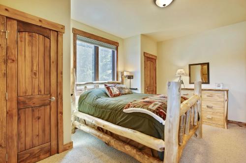 a bedroom with a wooden bed and a window at Slopeside Villa 126 Next To WP Resort I Steam Shower I Great Views I Private Hot Tub I Activity Program in Winter Park