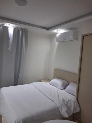 a bedroom with a white bed and a window at Studio at El Karma Beach & Aqua Park in Hurghada