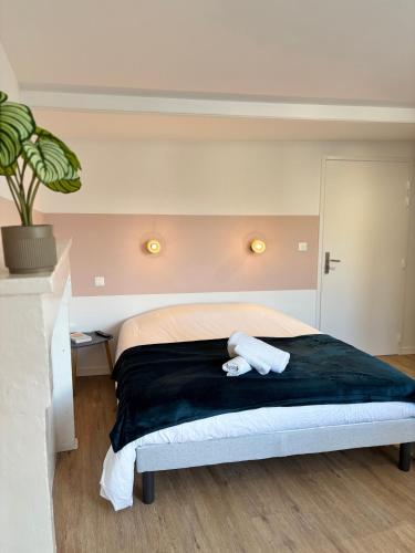 a bedroom with a bed with two towels on it at Studio Le Dolmen Château-Larcher Arrivée autonome in Château-Larcher