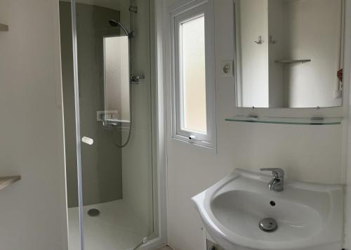 a white bathroom with a sink and a shower at rouge gorge in Valras-Plage