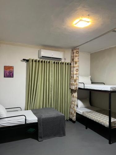a room with two bunk beds and a window at Sundays Hostel Sigiriya in Sigiriya