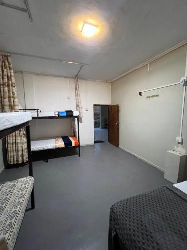 a room with two bunk beds and a hallway at Sundays Hostel Sigiriya in Sigiriya