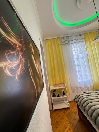 a bedroom with a large picture hanging on the wall at The sweet room in Ganja