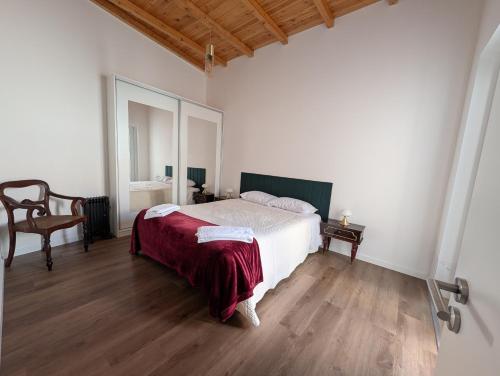 a bedroom with a bed with a red blanket on it at Casas Albano 1 in Caldas da Rainha