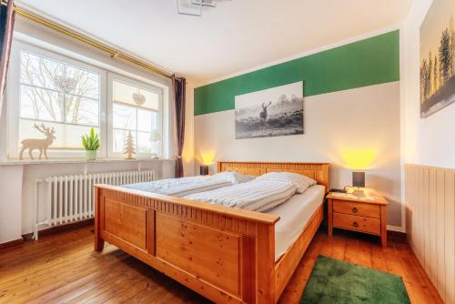 a bedroom with a bed and a green and white wall at Altes Forsthaus Königskrug in Braunlage