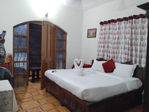 a bedroom with a large bed with white sheets at Flobestian's Seafront Villa in Candolim