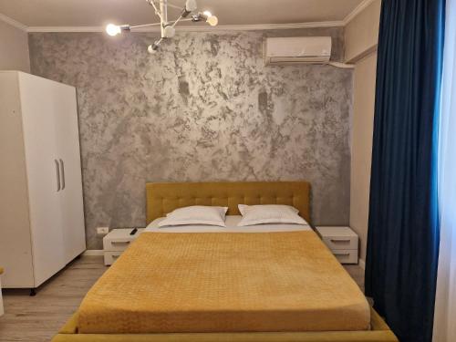 a bedroom with a bed and a wall at Sunny Studio Mamaia Nord in Mamaia Sat/Năvodari