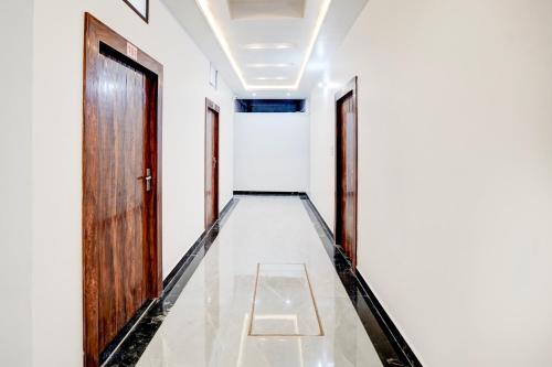 an empty corridor with two doors and a tile floor at HOTEL O SAMRAT INN in Prayagraj