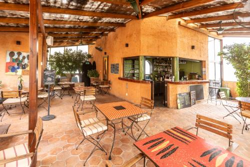 a patio with tables and chairs and a bar at Hotel Le Djoloff in Dakar