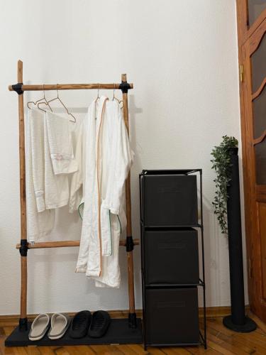 a clothes rack with white clothes and shoes on it at The sweet room in Ganja