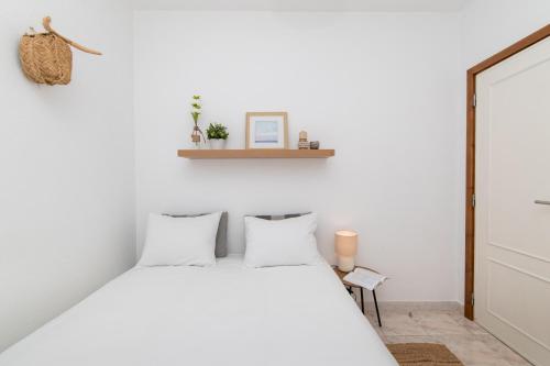 a bedroom with a white bed with white pillows at Sesimbra Cozy House BBQ & Terrace - MADA HOUSE's in Sesimbra