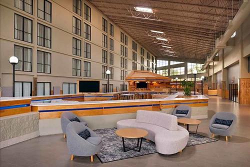 a lobby with couches and chairs in a building at Urbana Hotel Conference Center in Urbana