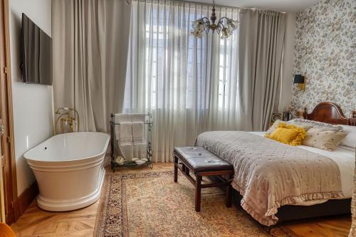 a bedroom with a large bed and a bath tub at Hotel Boutique Cata & Rose - Exclusivo y tranquilo en O Grove in O Grove