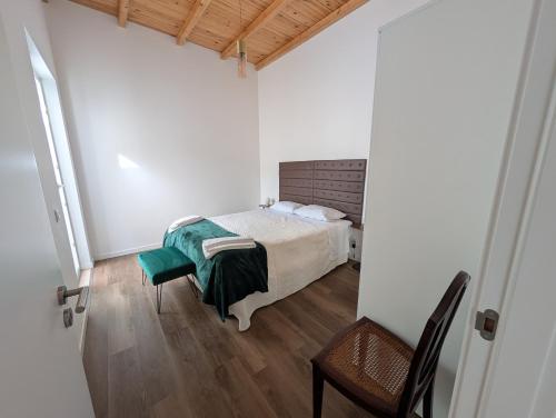 a bedroom with a bed and a table and a chair at Casas Albano 2 in Caldas da Rainha