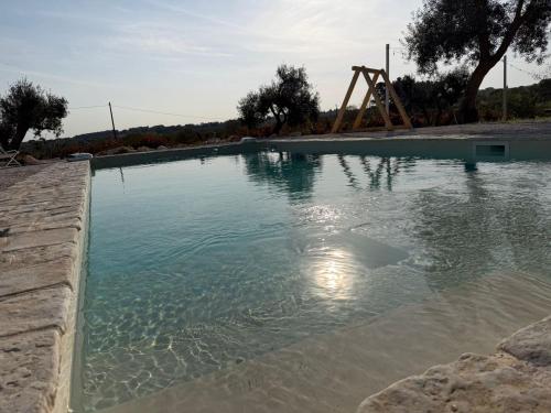a pool of water with a slide in the background at Trulli Fichi Luxury Trullo with Private Spa and Saltwater Pool in Santa Lucia