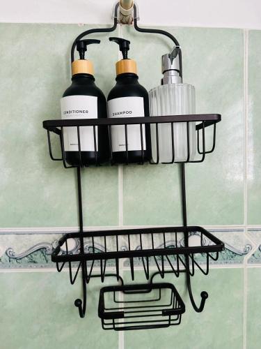a black shelf with four bottles on a wall at Papagayo in Bayahibe