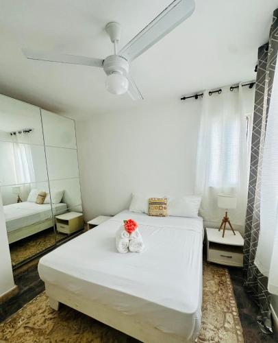 a white bedroom with a bed and a mirror at Papagayo in Bayahibe